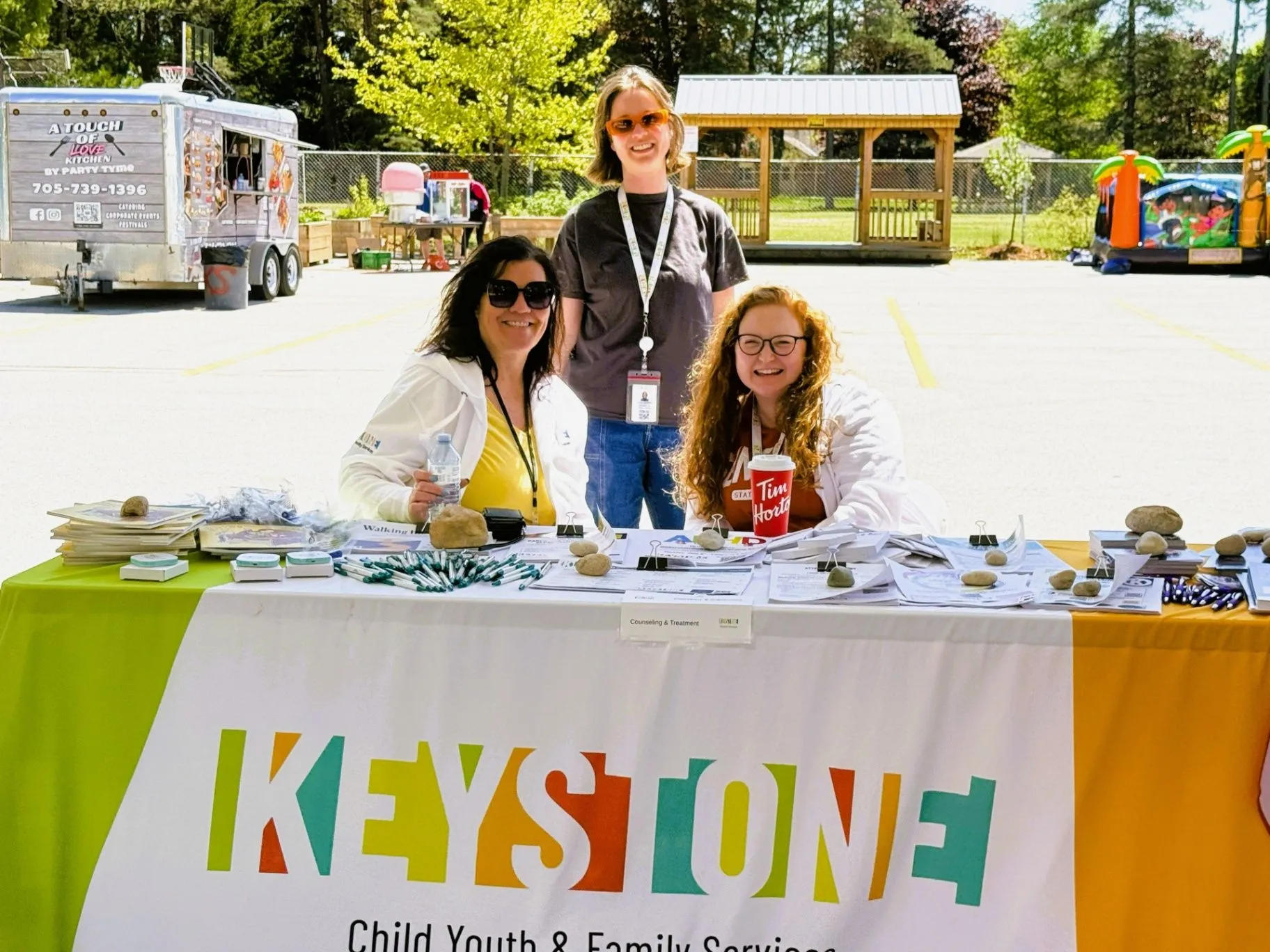 Keystone staff at a community booth with a service table banner